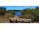 A wooden bench overlooks a serene waterway, offering a peaceful spot to relax and enjoy the natural surroundings at 1110 93Rd Nw St, Bradenton, FL 34209