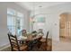 Dining room with a wooden table set with dishes, large windows and a view of adjacent areas of the home at 1110 93Rd Nw St, Bradenton, FL 34209