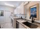 Bright laundry room with granite counters, stainless sink, and ample cabinet space at 1110 93Rd Nw St, Bradenton, FL 34209