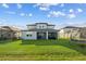 Wide backyard features well-kept lawn and a view of the lake with beautiful neighboring homes in the background at 11221 Gallatin Trl, Parrish, FL 34219