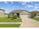 Well-maintained home with a green lawn, mature trees, and a convenient two-car garage at 11221 Gallatin Trl, Parrish, FL 34219