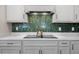 Modern kitchen features gray cabinets, a sleek cooktop, and a beautiful backsplash at 11221 Gallatin Trl, Parrish, FL 34219