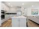 Modern kitchen with white cabinets, stainless steel appliances, and a large center island at 11221 Gallatin Trl, Parrish, FL 34219