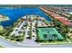 Breathtaking aerial view of the community clubhouse, tennis courts, and pool overlooking the serene lake and surrounding residences at 116 Pescador Pl, Nokomis, FL 34275
