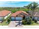 Beautiful single-Gathering home with a tile roof, a brick driveway, tropical landscaping, and a three-car garage at 116 Pescador Pl, Nokomis, FL 34275