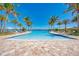 Resort-style pool area featuring ample lounge space and views of the serene waterfront in a tropical landscaped setting at 116 Pescador Pl, Nokomis, FL 34275