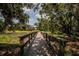 Charming wooden bridge surrounded by lush greenery, enhancing the scenic walking experience at 11790 Fennemore Way, Parrish, FL 34219