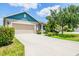 Charming single-story home featuring a two-car garage, blue accents, and meticulously maintained landscaping at 11790 Fennemore Way, Parrish, FL 34219