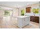 Bright, open concept kitchen featuring modern island, lots of natural light, and stylish pendant lighting at 11790 Fennemore Way, Parrish, FL 34219