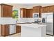 Modern kitchen with dark wood cabinets, stainless steel appliances, white marble countertops, and an island at 11790 Fennemore Way, Parrish, FL 34219