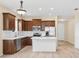Modern kitchen with dark wood cabinets, stainless steel appliances, white marble countertops, and an island at 11790 Fennemore Way, Parrish, FL 34219