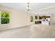Spacious living room flowing into a modern kitchen, abundant natural light, and a neutral color scheme at 11790 Fennemore Way, Parrish, FL 34219