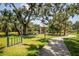 Community playground with mature trees and a walking path, offering a Gathering-friendly outdoor space at 11790 Fennemore Way, Parrish, FL 34219