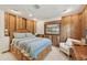Comfortable bedroom featuring wood paneling, a ceiling fan, and a window with natural light at 1248 Jefferson Dr, Englewood, FL 34224