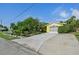 Charming home with a bright yellow exterior, two-car garage, and lush tropical landscaping at 1248 Jefferson Dr, Englewood, FL 34224