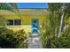 Bright and inviting front door with a modern design surrounded by lush tropical landscaping at 1248 Jefferson Dr, Englewood, FL 34224