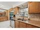 Kitchen with stainless steel dishwasher, stone countertops, and view to the adjacent Gathering room at 1248 Jefferson Dr, Englewood, FL 34224