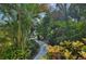 A serene landscaped path winds through lush greenery, creating a private and inviting entrance at 1248 Jefferson Dr, Englewood, FL 34224