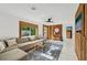 Bright living room with a large sectional sofa, wood paneling, and a view to the outdoors at 1248 Jefferson Dr, Englewood, FL 34224