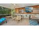 Inviting covered patio with ample seating, ceiling fans, and a mounted TV for entertainment at 1248 Jefferson Dr, Englewood, FL 34224