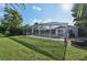 A nice enclosed screened lanai around an in-ground pool overlooks the grass lawn and tropical landscaping at 1248 Jefferson Dr, Englewood, FL 34224