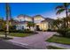 Stunning two-story home featuring a tile roof, well-manicured landscaping, and a brick-paved driveway at 125 12Th E Ave, Palmetto, FL 34221
