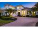 Elegant home boasts manicured lawns, decorative shrubbery, a tile roof, and a circular brick driveway at 125 12Th E Ave, Palmetto, FL 34221