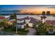 Waterfront home featuring lush landscaping, a tile roof, and a circular driveway overlooking a scenic harbor view at sunset at 125 12Th E Ave, Palmetto, FL 34221
