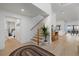 Bright foyer boasts wood floors, an open staircase, modern decor, and views through to an open plan living space at 125 12Th E Ave, Palmetto, FL 34221