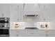 Close-up view of a modern kitchen featuring white cabinetry and stainless steel appliances at 125 12Th E Ave, Palmetto, FL 34221
