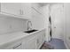 Bright laundry room boasts modern cabinetry, a sink, and stacked washer and dryer at 125 12Th E Ave, Palmetto, FL 34221