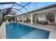 Beautiful waterfront pool area featuring an outdoor kitchen, dining, and comfortable seating for luxurious relaxation at 125 12Th E Ave, Palmetto, FL 34221