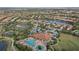 Aerial view showcases community with pool, tennis courts, lake, and homes highlighting the lifestyle amenities at 12659 Sorrento Way, Bradenton, FL 34211
