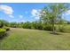 Expansive backyard features a lush lawn, pond views, mature trees, and privacy at 12659 Sorrento Way, Bradenton, FL 34211