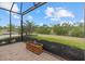 Enclosed outdoor patio with views of the landscaped backyard and surrounding greenery at 12659 Sorrento Way, Bradenton, FL 34211