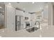 Modern kitchen with stainless steel appliances, granite counters, white cabinets, and tile backsplash at 12659 Sorrento Way, Bradenton, FL 34211