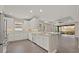 Bright kitchen featuring white cabinets, stone countertops, modern appliances, and wood flooring at 12659 Sorrento Way, Bradenton, FL 34211