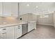 Bright kitchen features white cabinets, granite countertops, stainless steel appliances, and wood-look tile flooring at 12659 Sorrento Way, Bradenton, FL 34211