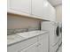 Functional laundry room featuring granite countertop, cabinets, sink, and washer-dryer at 12659 Sorrento Way, Bradenton, FL 34211