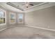 Spacious main bedroom with a tray ceiling, neutral carpet, and large windows for natural light at 12659 Sorrento Way, Bradenton, FL 34211