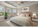 Bright main bedroom with tray ceiling, large windows and soft, neutral decor at 12659 Sorrento Way, Bradenton, FL 34211