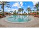 Resort style pool featuring tropical landscaping, palm trees, orange lounge chairs, and cabanas at 12659 Sorrento Way, Bradenton, FL 34211