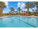 Inviting swimming pool with poolside cabanas and lounge chairs, surrounded by lush palm trees at 12659 Sorrento Way, Bradenton, FL 34211
