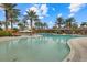 Large community pool featuring lounge chairs, umbrellas, and well-maintained landscaping for relaxing and enjoying the outdoors at 12659 Sorrento Way, Bradenton, FL 34211