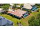 Aerial view of the home with lush landscaping, a screened pool, and a tile roof at 13105 Peregrin Cir, Bradenton, FL 34212