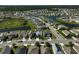 Aerial view of neighborhood featuring modern homes, manicured lawns, and a serene pond at 15408 Trinity Fall Way, Bradenton, FL 34212