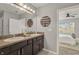 Bathroom featuring a double vanity with dark cabinets and a large mirror at 15408 Trinity Fall Way, Bradenton, FL 34212