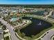 Community pool and pond surrounded by homes, trees, and manicured lawns in an aerial view at 15408 Trinity Fall Way, Bradenton, FL 34212