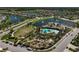 Aerial view of a community pool, playground, and pond surrounded by homes at 15408 Trinity Fall Way, Bradenton, FL 34212
