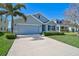 Charming single-story home featuring a well-manicured lawn, palm tree, and attached two-car garage at 15408 Trinity Fall Way, Bradenton, FL 34212